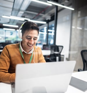 KB4-CR-0599-happy-young-man-working-on-his-computer-at-his-desk-800x860-Crop
