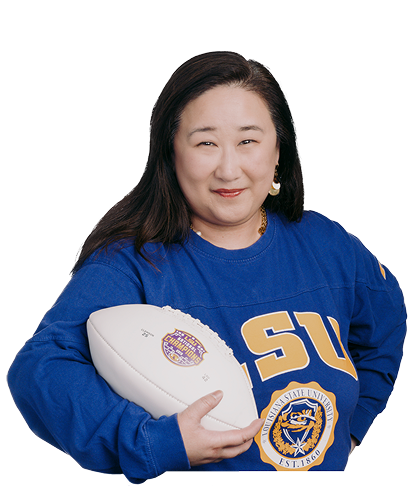 Cindy wearing an LSU sweater and holding a football