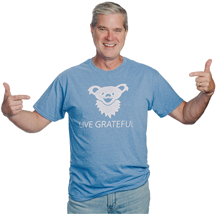 Joel wearing a blue shirt that reads "Live Grateful"